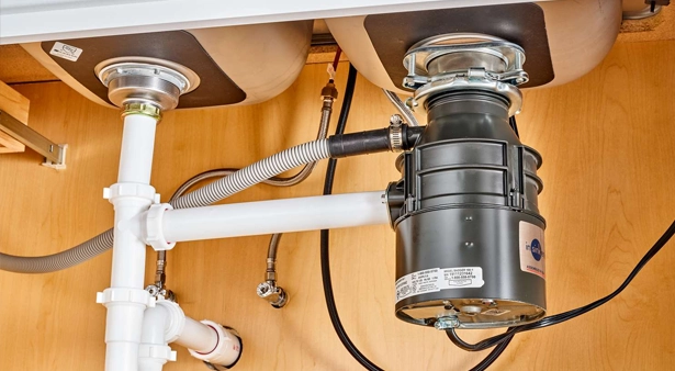 Under-sink plumbing with dual basins and garbage disposal unit.