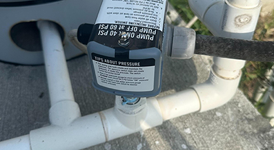 Pressure valve and PVC pipes on outdoor concrete surface.