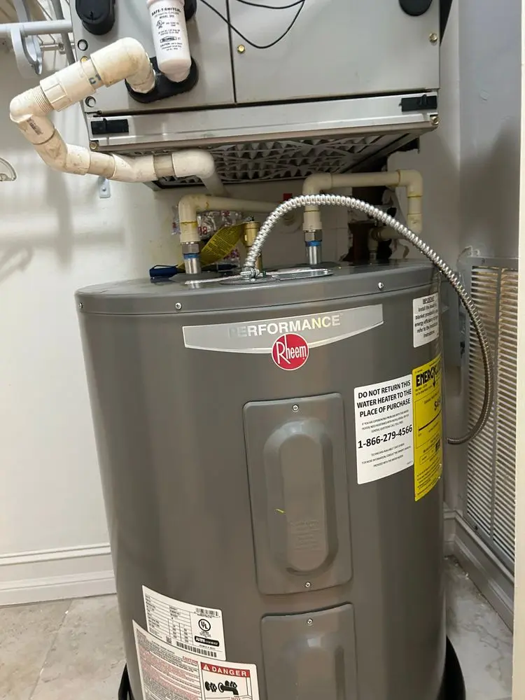 Water heater with pipes in a utility room.