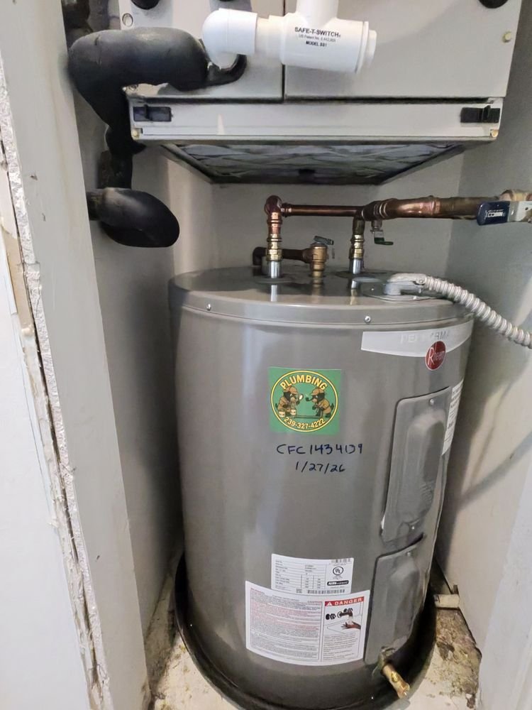 Water heater tank installed in a small utility closet with visible pipes.
