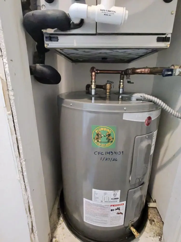 Water heater tank installed in a small utility closet with visible pipes.